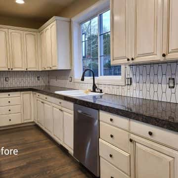 A modern kitchen with white cabinets and stainless steel appliances in Tigard.