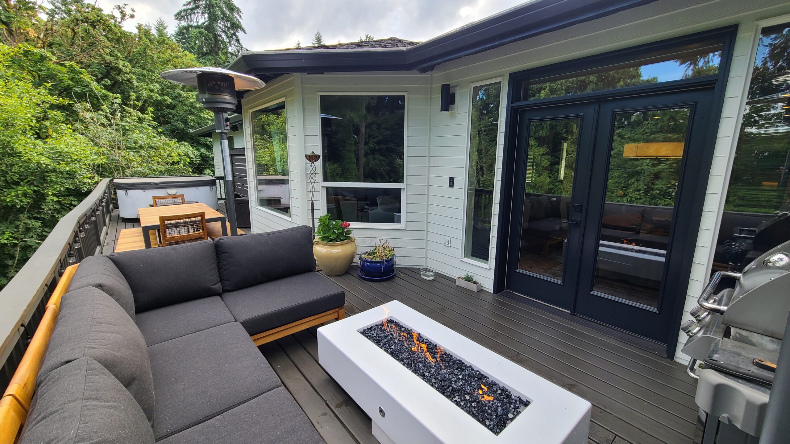 This Bull Mountain deck in Tigard combines modern style with unbeatable curb appeal, featuring a cozy fire pit and a comfortable couch.