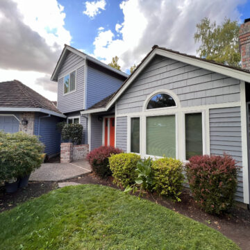 The Beaverton home features a vibrant exterior paint with blue siding and a red door.