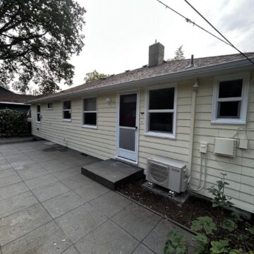Single-story Gies house in Portland with beige siding, painted by Pearl Painters. AC unit by patio. Multiple windows visible.