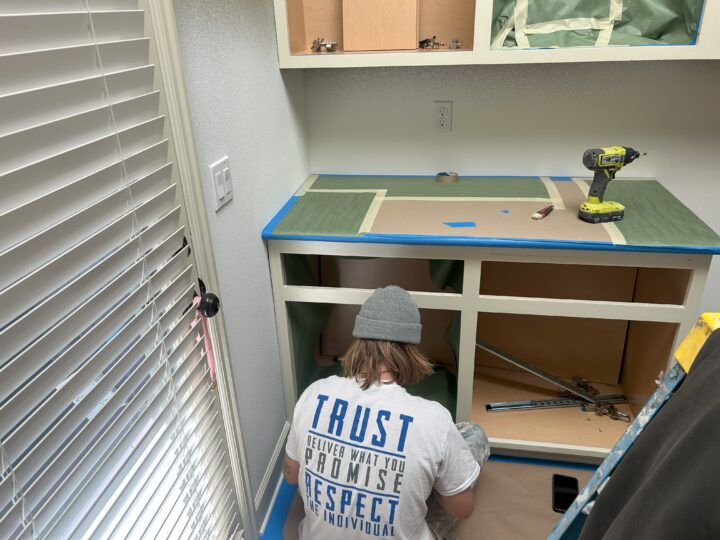 A painter is working on a cabinet in a room.