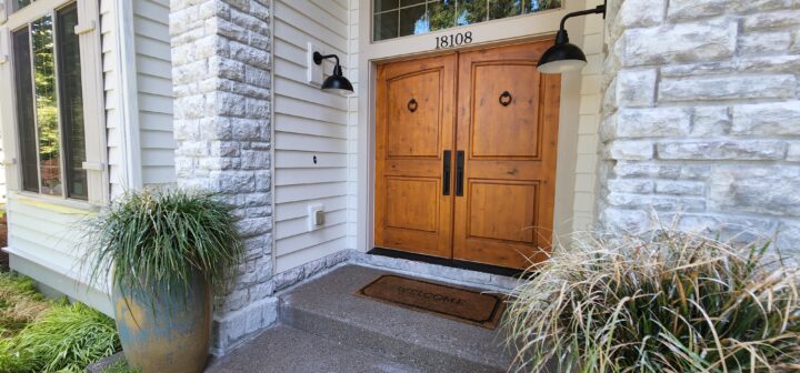A house with a wooden front door and a potted plant.