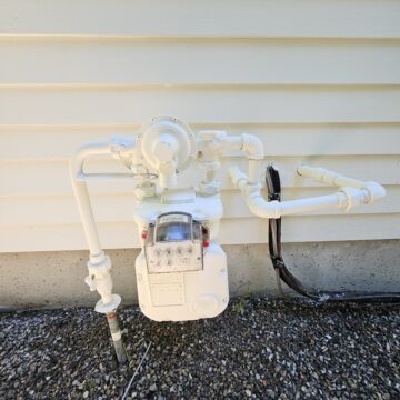 A white water meter on the side of a house in West Portland Park.