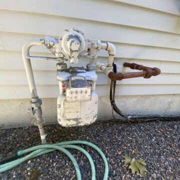 A water meter with a hose attached to it in Lake Oswego.