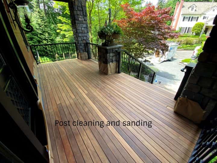 A wood deck in NW Portland with a black railing and a stone wall.