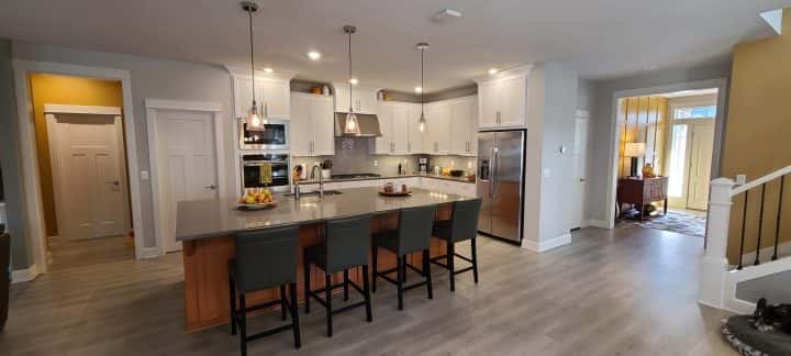 A kitchen with hardwood floors and stainless steel appliances in a funky style.