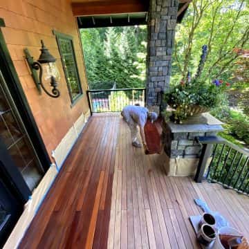 A man is working on a wooden deck in NW Portland, conducting deck restoration.