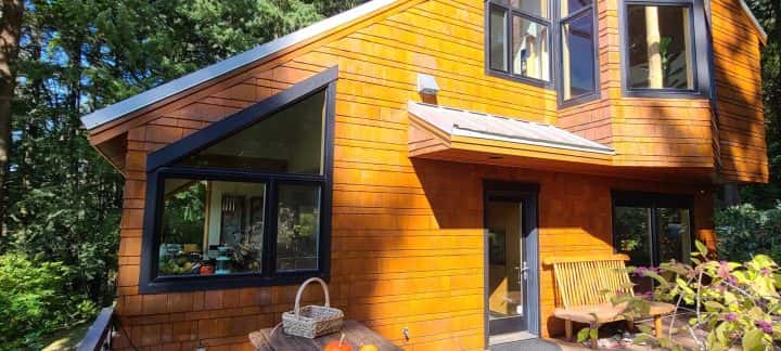 A tiny house in NW Portland nestled in the woods with a beautiful wooden deck ready for your stain project.