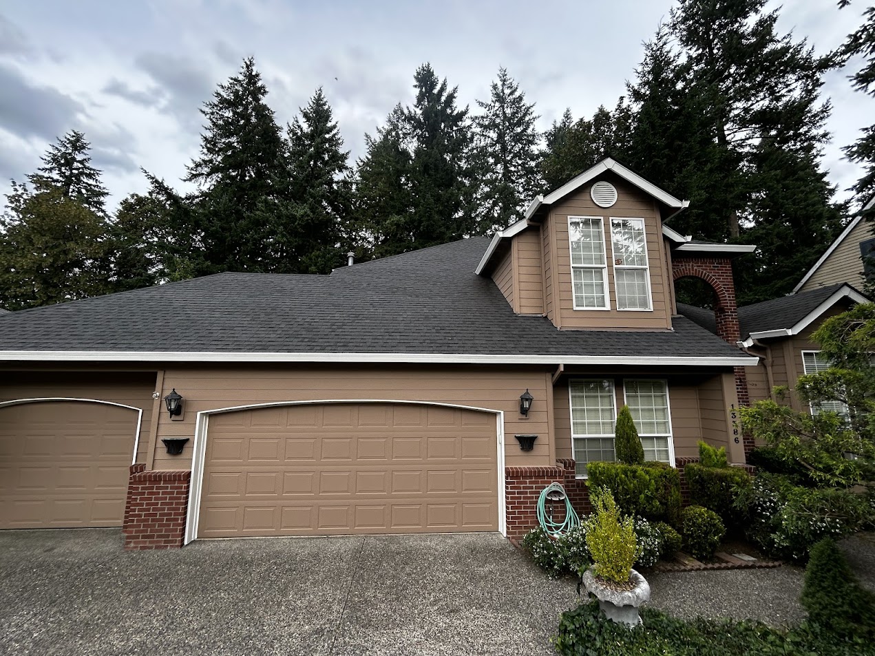 Charming two-story Haase house in Portland with brown exterior, brick accents, two-car garage, and front garden. Pearl Painters will complete painting by June 2025.