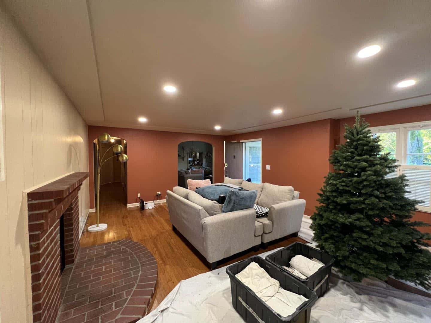 A cozy living room with a fireplace, a Christmas tree, and Santa decorations.