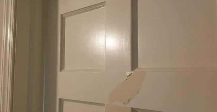 A white door with a piece of tape on it.