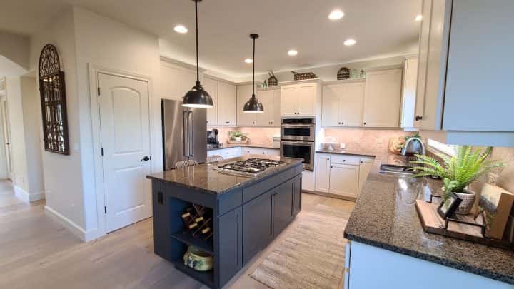 A kitchen with granite counter tops and stainless steel appliances, perfect for cabinet painting.