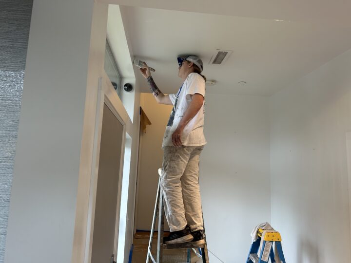 A thoughtful man working on a townhouse painting project, aiming for a 5-star Google Review.