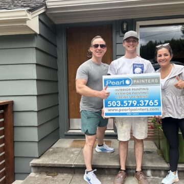 Three people stand outside a Carlton house, holding a Pearl Painters sign for painting services. The sign includes contact details and notes booking into June 2025.
