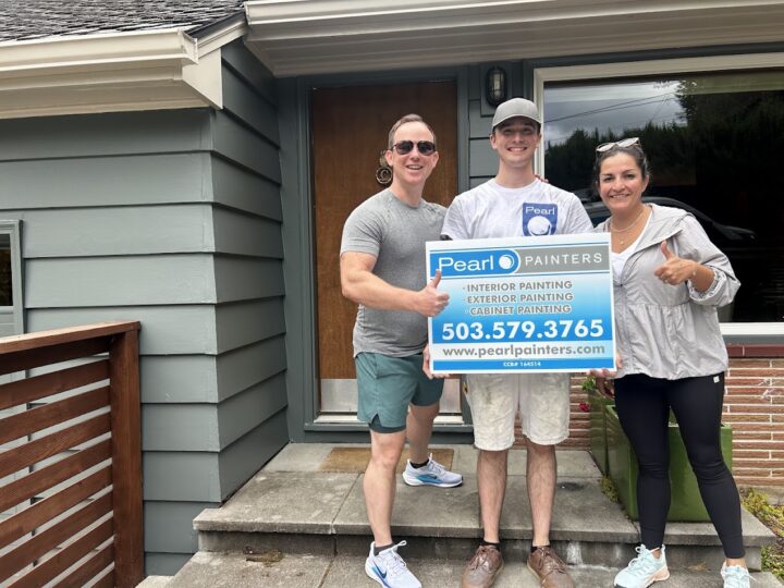 Three people stand outside a Carlton house, holding a Pearl Painters sign for painting services. The sign includes contact details and notes booking into June 2025.