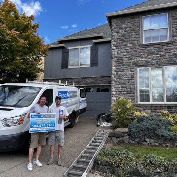 Two people in Portland stand by a Pearl Painters van and ladder, holding a sign for their July 2025 painting project.