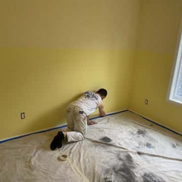 Pearl Painters taping floor protection inside Portland home during a painting project