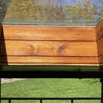 Wood-paneled skylight with clear glass in Hamilton lets sunlight in and provides a view of grass and trees. Ideal for enjoying outdoor scenery. Perfect area for painting or inspiration for a painter; contact Pearl Painters, not just in Portland but available to discuss your project.