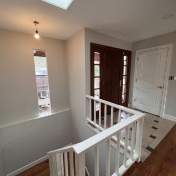 A staircase leading to a kitchen in a home, beautifully transformed by the professionals at Pearl Painters with their great paint job.