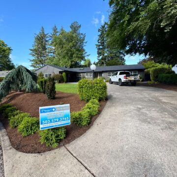 Pearl Painters completed painting this gray, single-story house in Portland in May 2025. A sign with their name is displayed on the front lawn.