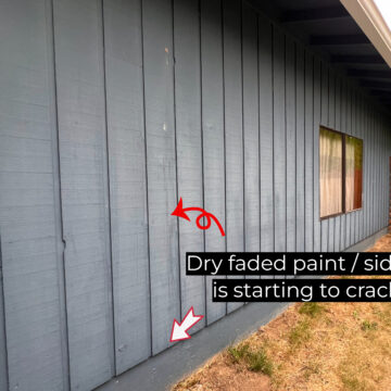 A blue wooden exterior wall of a house with dry, faded paint shows signs of cracking on the siding. There is a window and a red arrow pointing to the cracks with a text overlay indicating exterior painting problems.