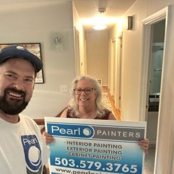 A man and woman holding a sign that says Pearl Painters in Portland.