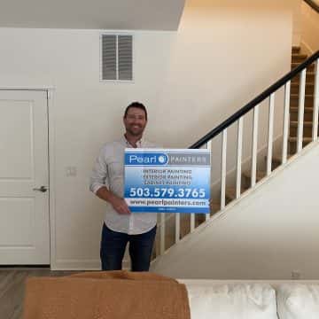 Happy customer in front of painted staircase in his home