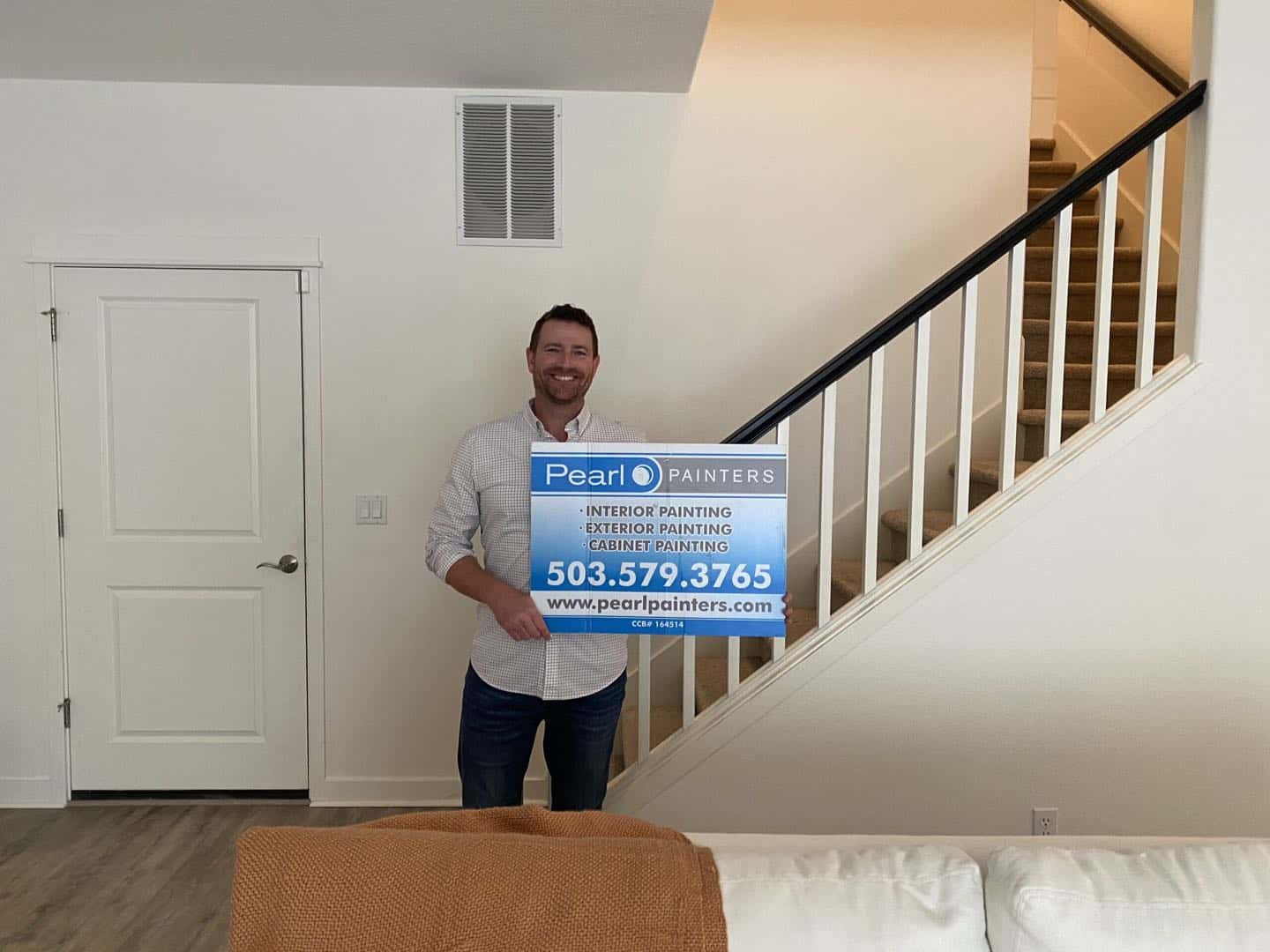 Happy customer in front of painted staircase in his home