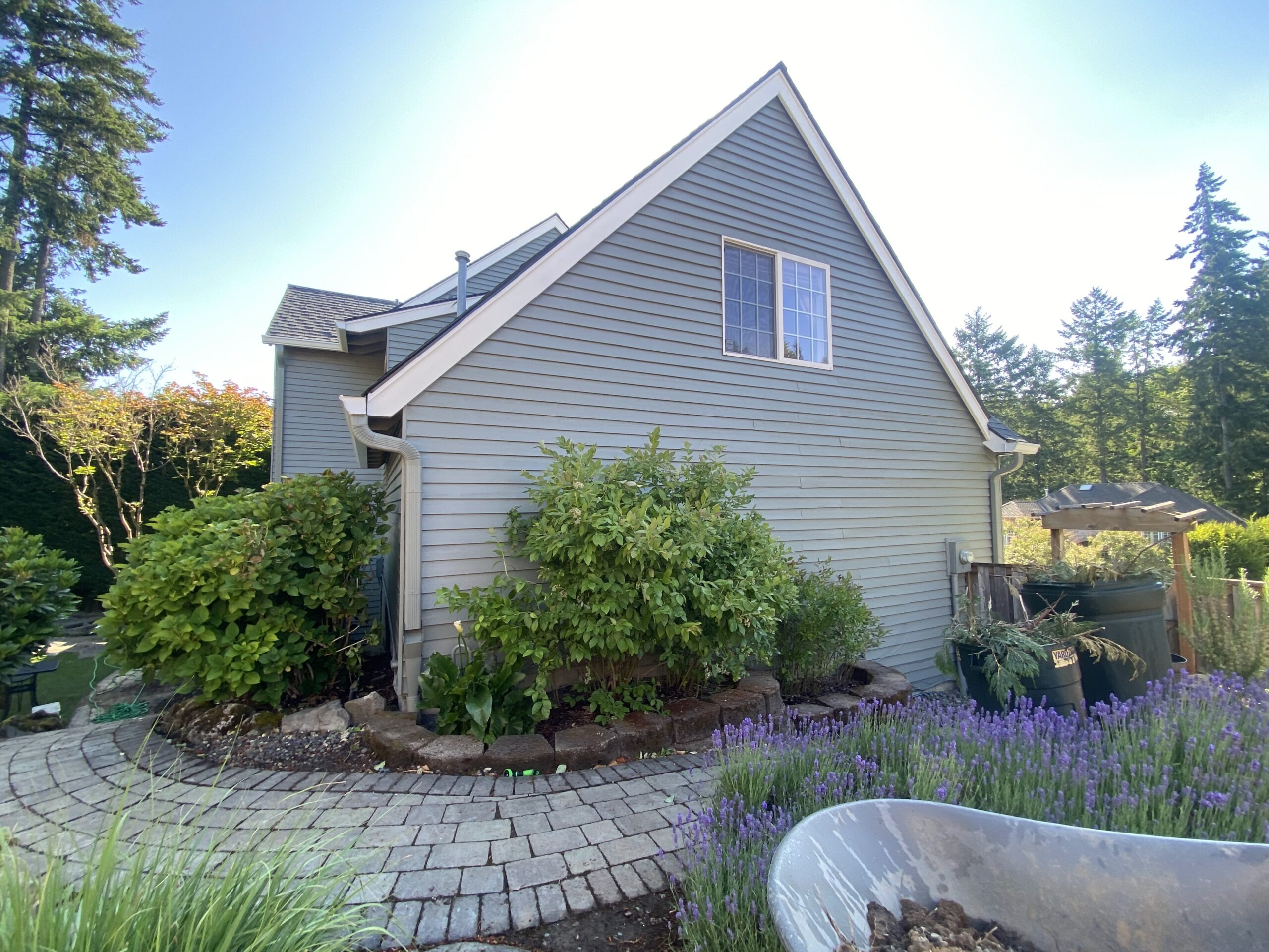 A charming house nestled in the Bull Mountain Neighborhood, featuring a picturesque garden and a convenient wheelbarrow for your next Painting Project.