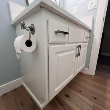 A dazzling white bathroom vanity with a toilet paper holder.