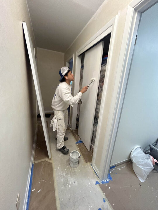 Portland painter painting a door in Deanne's home.