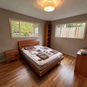 A bedroom with hardwood floors and a bed.