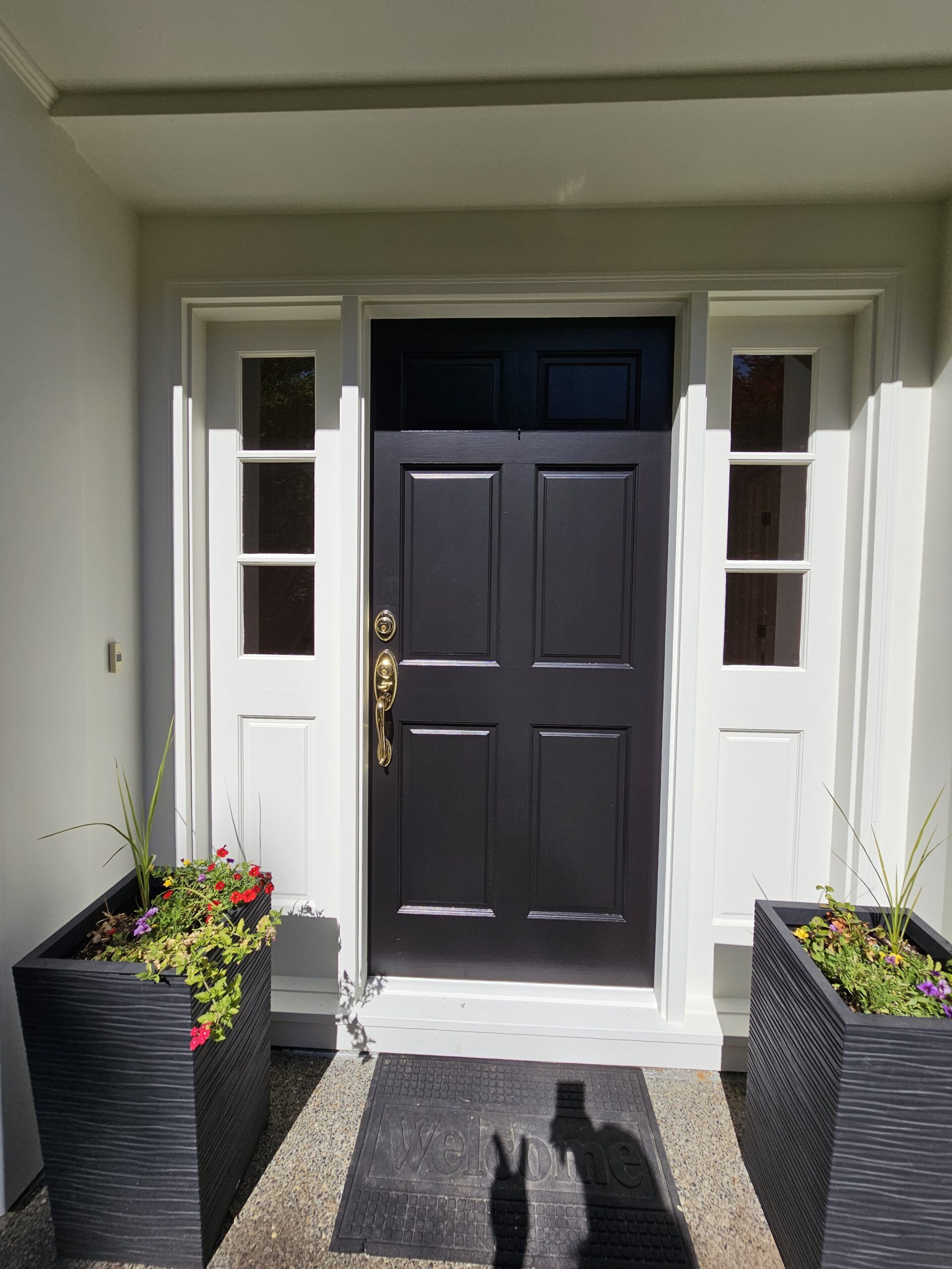 A revitalizing home in Portland Park with a black front door and planters in front of it.