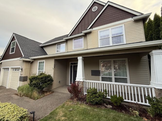 Beige two-story house with brown trim, garage, front porch, and yard in Montoya. Painted by Pearl Painters of Portland.