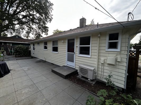 Single-story Gies house in Portland with beige siding, painted by Pearl Painters. AC unit by patio. Multiple windows visible.