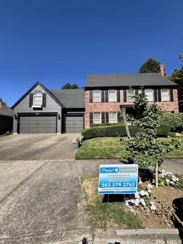 Portland house with brick and dark gray exterior, painted by Pearl Painters. Yard sign shows project finished Aug. 2025.