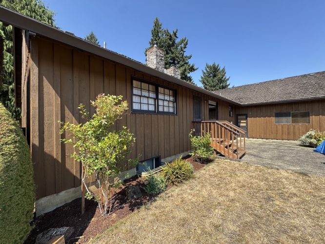 Brown wooden house with porch, stairs, garden shrubs; painted in Craytor by Pearl Painters. Painter style; not Portland.