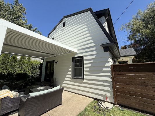White house with black trim, patio, and fencing. Painted by Pearl Painters in Portland. Photo: Johnson, Aug 2025.
