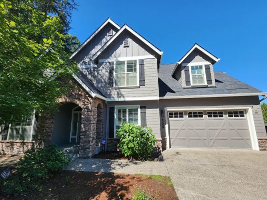 Holley two-story house in Portland with gray siding and stone accents; painted by Pearl Painters. Completion by July 2025.