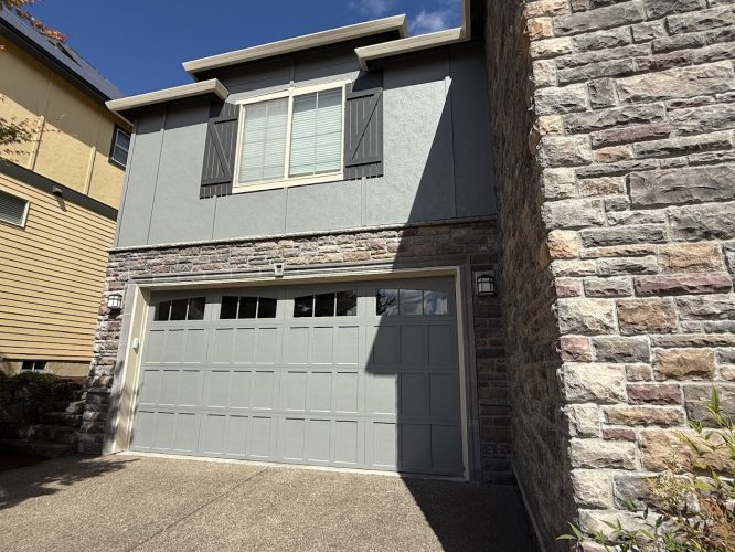 Pearl Painters painting in Portland: Doan house with a two-car garage, light gray door, closed-shutter window, stone and gray siding.
