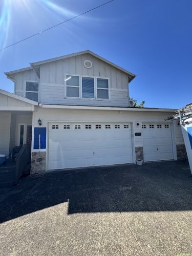 A two-story white Jennings house with a three-car garage, painted by Pearl Painters near Portland, July 2025.
