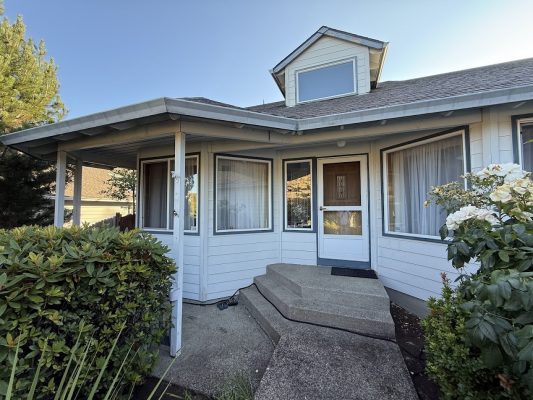 Light blue house exterior in Portland with porch and white windows, painted by Pearl Painters, July 2025 for Nomura.