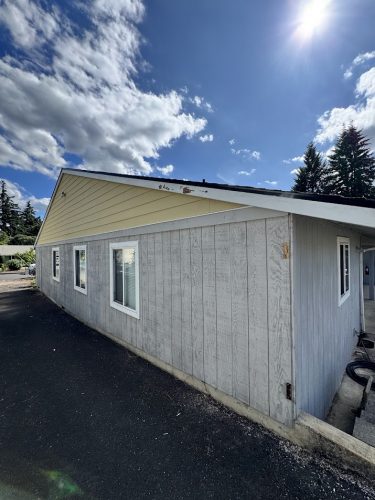 Gray and yellow single-story house with white windows and asphalt drive, painted by Pearl Painters in Portland, July 2025.