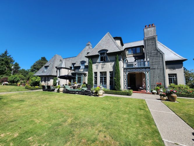 Gray Tudor-style house with steep roof and chimneys, painted by Pearl Painters in Portland. Debuts August 2025.