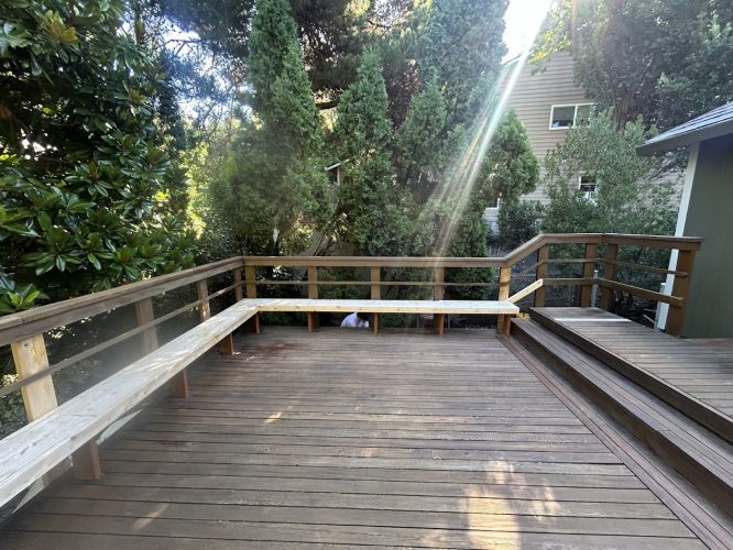 Wooden Pitney deck with benches, greenery, and sunlight. House in back. Painted by Pearl Painters in Portland.