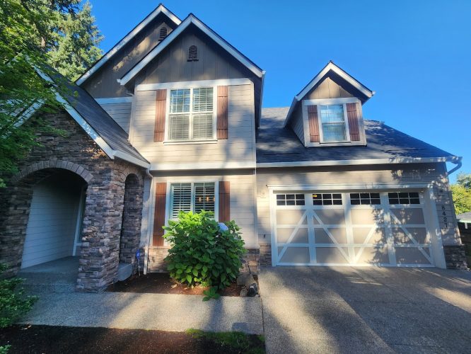 Two-story house in Holley with gray siding, stone accents, and brown shutters, painted by Pearl Painters near Portland.