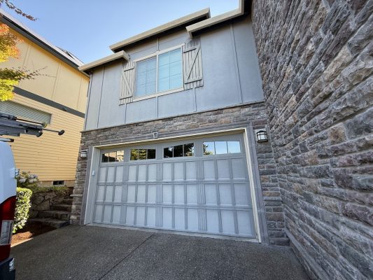Two-story house with stone, gray siding, shuttered windows. Pearl Painters van visible. Doan listing, July 2025, Portland.