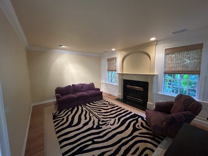 Painted by Pearl Painters in Portland, this living room has cream walls, a fireplace, windows, zebra rug, purple seating.