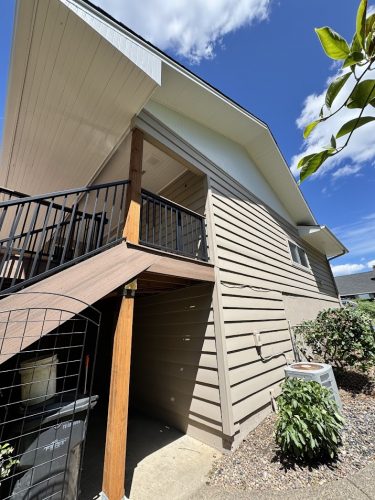 Cleveland two-story house with beige siding, black metal railings, AC unit; painted by Pearl Painters under blue July 2025 sky.
