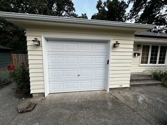 White Gies garage door, lantern lights, yellow house in Portland; concrete driveway and steps painted by Pearl Painters.